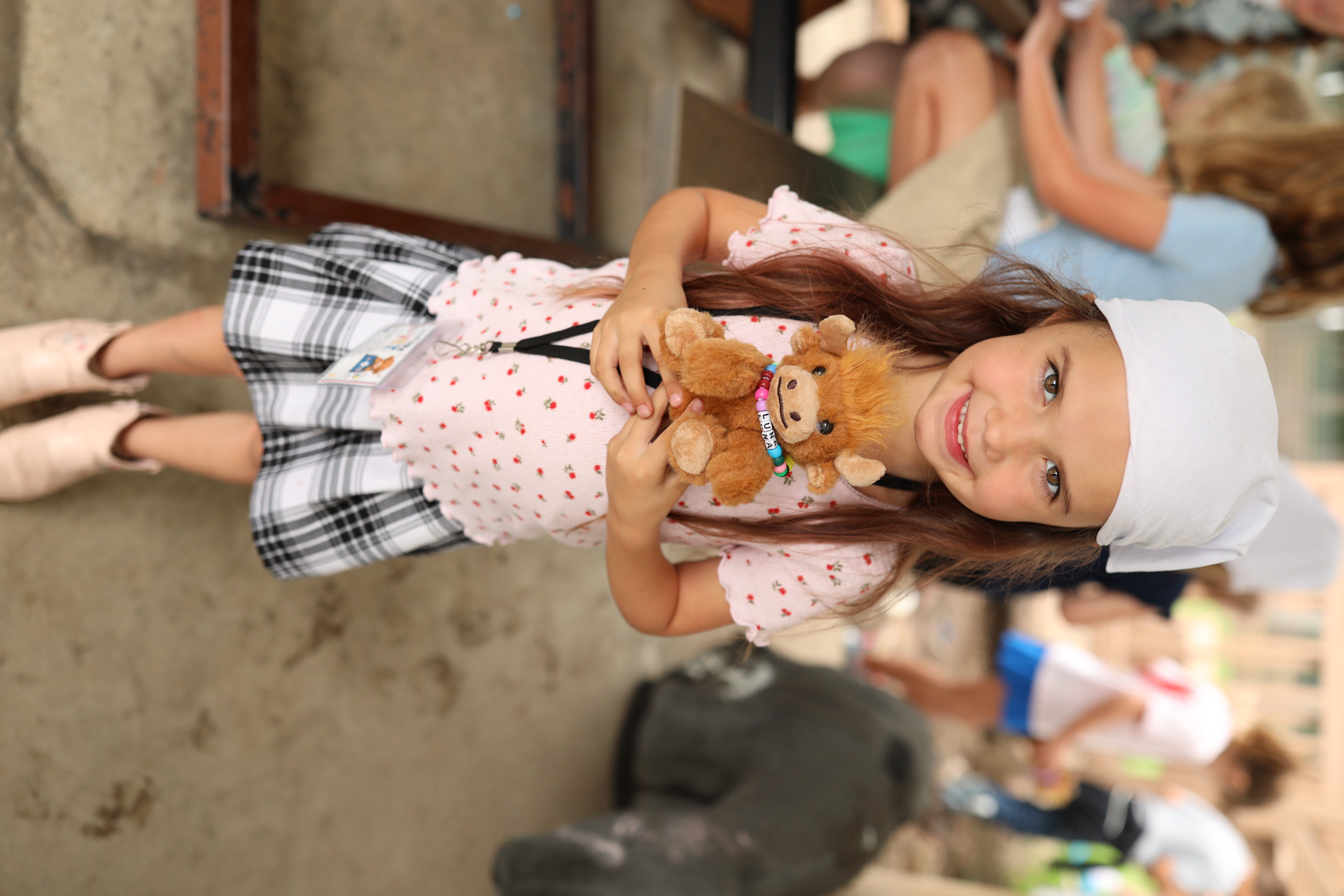 A child holding her adopted Highland cow named Luna with a beaded name collar